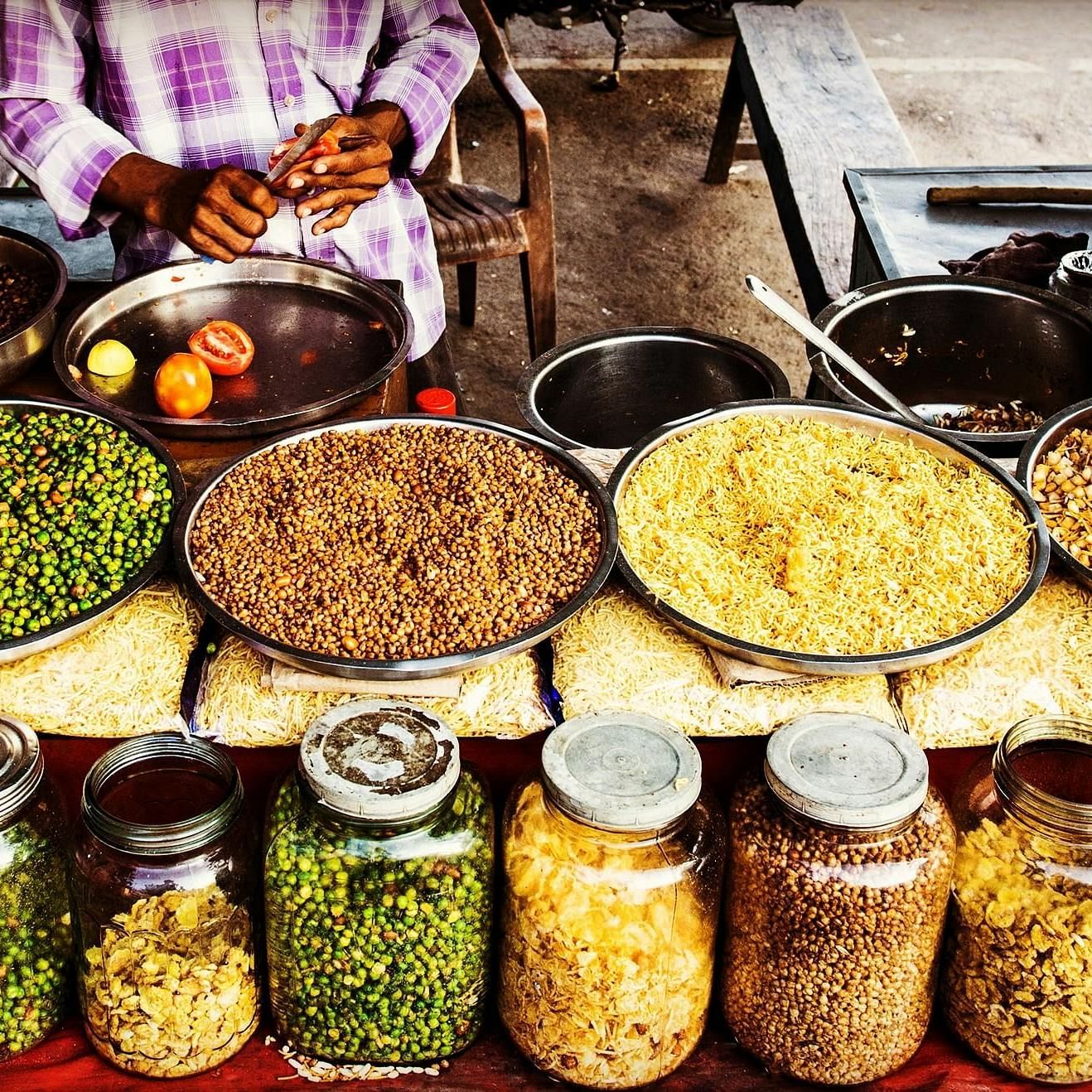 A man is standing in front of a table filled with diverse food items